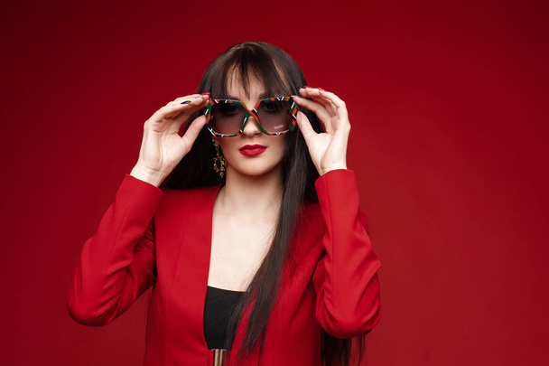 Side view of glamorous brunette posing in red smart suit - Foto, Imagem