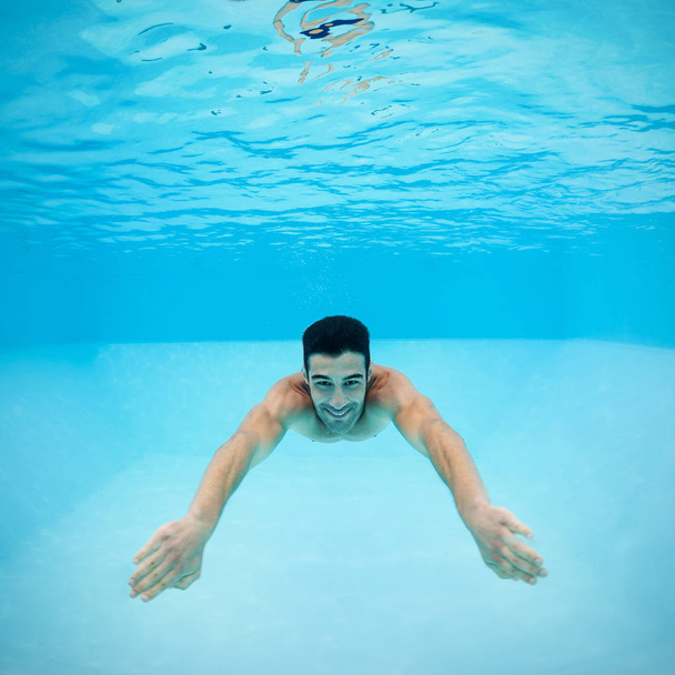 Underwater man inside swimming pool after dipping. - Foto, Imagen