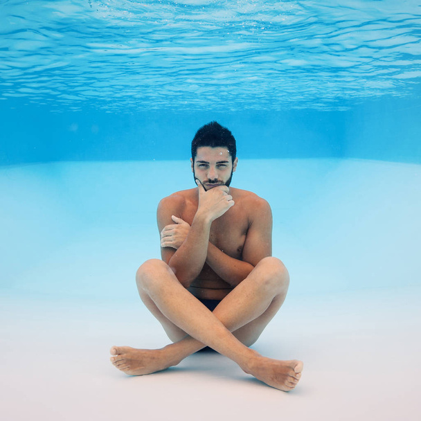 Underwater portrait of man thinking inside a swimming pool.  - Foto, Imagen