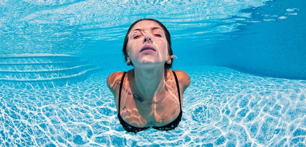 Sexy tattooed woman close up portrait wearing bikini underwater  - Фото, изображение