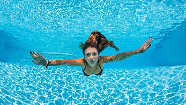 Sexy tattooed woman portrait wearing bikini underwater in swimmi - Photo, image