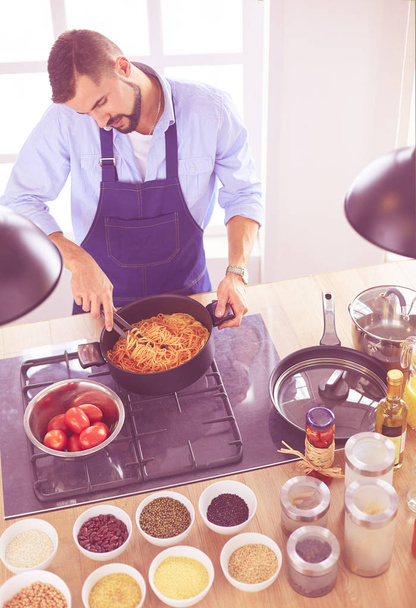 Mann bereitet leckeres und gesundes Essen in der heimischen Küche zu - Foto, Bild
