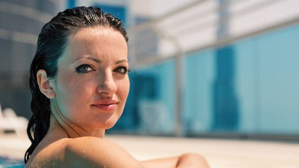 Intense woman close up portrait relaxingg in swimming pool in Dubai. Filtered image.  - Foto, afbeelding