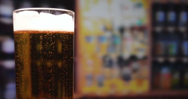 Two guys (women) in the bar (at home) drink beer clinking glasses, and then they open a new bottle. You can see how foam foams through the top in slow motion. - Footage, Video