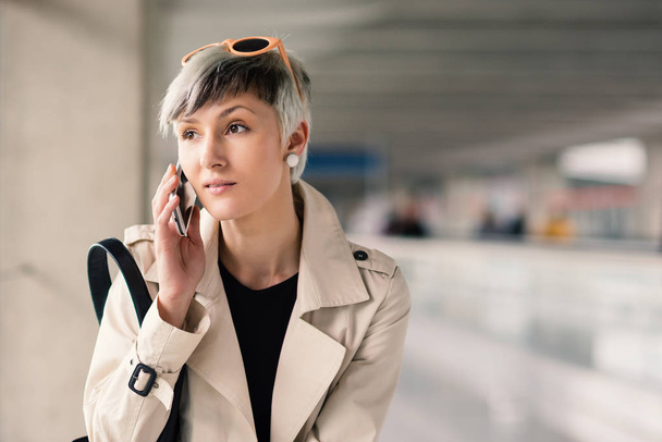 Businesswoman talking at mobile phone at Charles de Gaulle airport, Paris.  - Фото, изображение