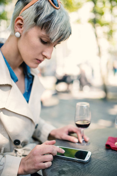 Молода жінка користується смартфоном у кафе в Парижі. Пустельна глибина.  - Фото, зображення