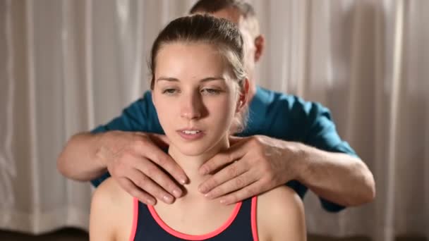 Mannelijke handmatige viscerale therapeut masseur behandelt een jonge vrouwelijke patiënt. Opwarmen van de schouders en nek - Video