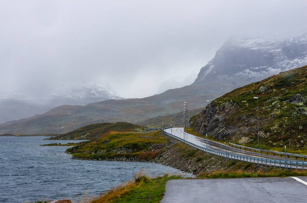 Estrada pelas terras altas norueguesas do Parque Nacional Hardangervidda
 - Foto, Imagem