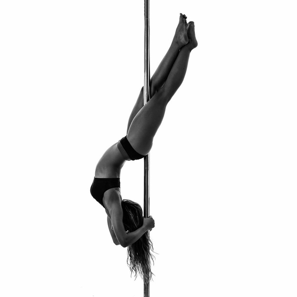 Silouette of woman performing pole dance. Studio shot, black and white image. - Foto, imagen