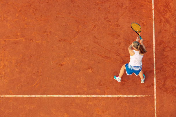 Aerial shot of a female tennis player on a court during match. Young woman playing tennis.High angle view. - Valokuva, kuva