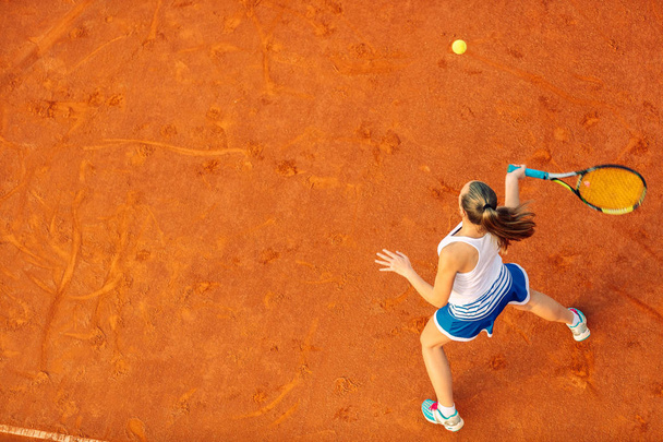 Aerial shot of a female tennis player on a court during match. Young woman playing tennis.High angle view. - Фото, зображення