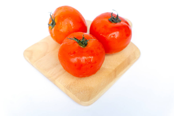 крупним планом червоні помідори ізольовані на білому тлі. Томат з краплями води. Свіжі помідори готові до приготування. Томати це овочі, які містять вітамін С і А. А також мають антиоксиданти, такі як бета-каротин і фосфор
.  - Фото, зображення
