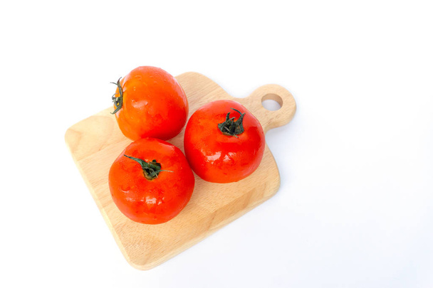 Uzavřete červená rajčata na bílém pozadí. Rajčata s kapičky vody. Čerstvá rajčata připravená k vaření. Rajčata jsou zelenina, která obsahuje vitamín C a a. A také mají antioxidanty jako lycopen beta-karoten a fosfor.  - Fotografie, Obrázek