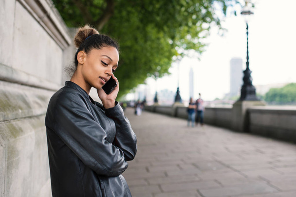 Young mixed race businesswoman portrait outdoors in London talki - Foto, Imagem