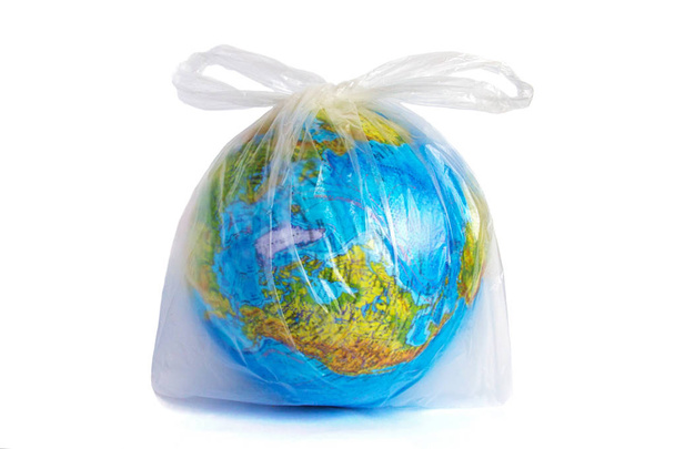 Earth in polyethylene plastic disposable package, isolated on white background. Concept pollution of environment with polyethylene plastic waste, ecological problems. Stop plastic pollution. - Zdjęcie, obraz
