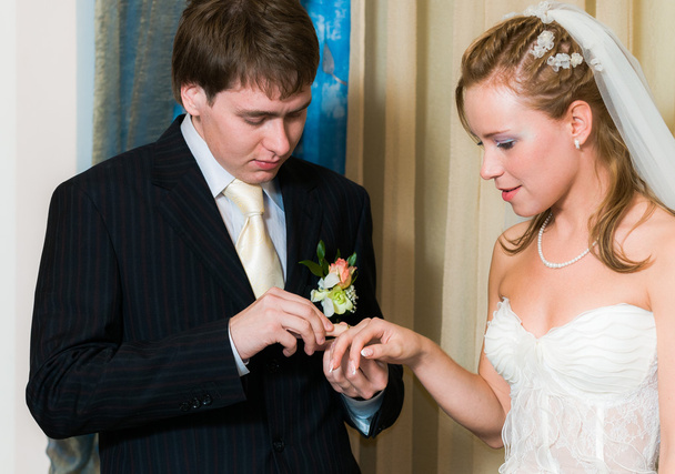 jonge bruidspaar zetten de ring - Foto, afbeelding