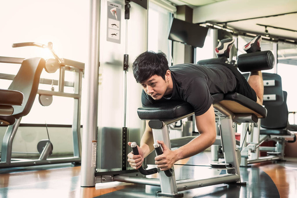 Asian sport man stretching and lifting weight by two legs when f - Photo, Image