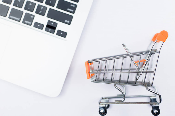 Shopping cart with laptop - Foto, afbeelding