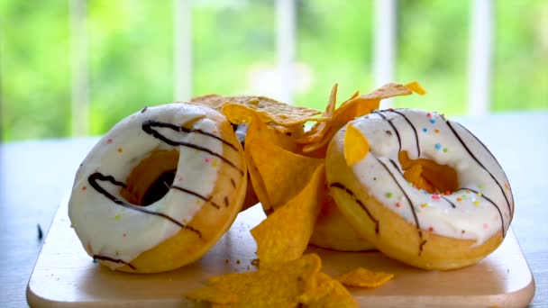 Chips fallen auf ungesunde Donuts - Filmmaterial, Video