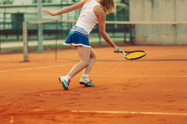 Beautiful female athlete with perfect body posing on tennis court, close up - Φωτογραφία, εικόνα