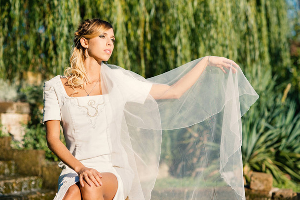 Young beautiful blonde bride intimate portrait outdoors in a par - Fotoğraf, Görsel