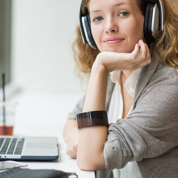 Businesswoman portrait while working with her laptop and listeni - Φωτογραφία, εικόνα