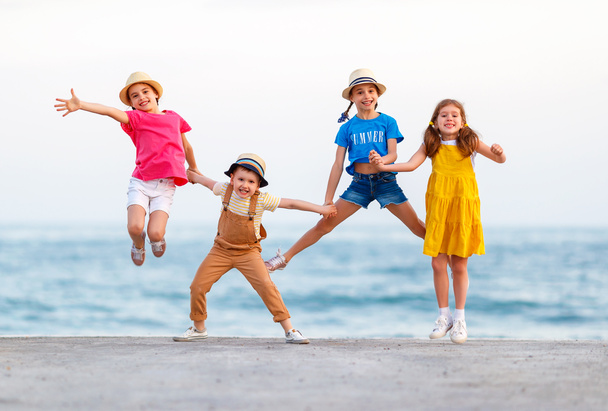 group of happy children jump by   sea in summe - Photo, Image