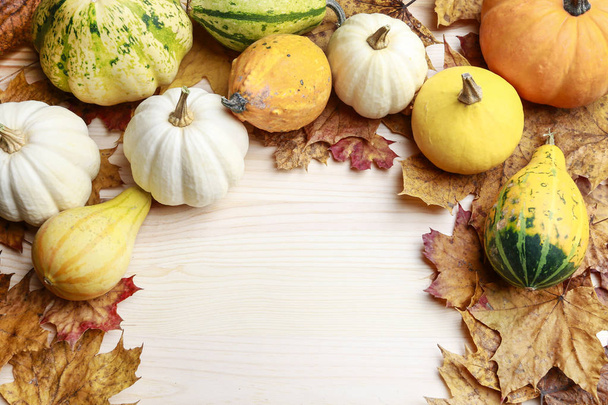 Pumpkins and leaves on wooden background - Photo, Image