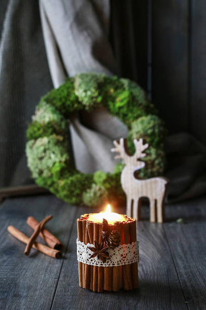Candle decorated with cinnamon sticks. Christmas time - Foto, afbeelding