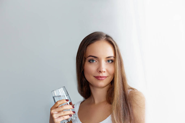 Healthy Diet Nutrition. Portrait Of Beautiful  Young Woman Taking Vitamin Pill looking in windows. Closeup Of Happy Girl Holding Colorful Capsule Pill And Glass Of Fresh Water.  - Foto, Bild