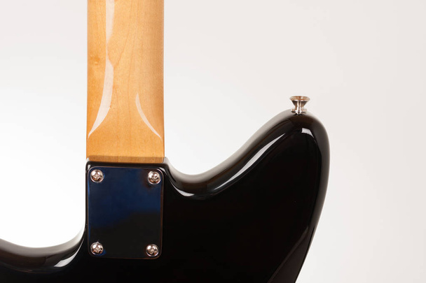Zbliżenie płyty szyi na czarnej gitarze elektrycznej ze sworznią na NEC - Zdjęcie, obraz