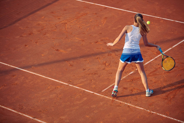 Young woman playing tennis on clay. Forehand. - Fotoğraf, Görsel