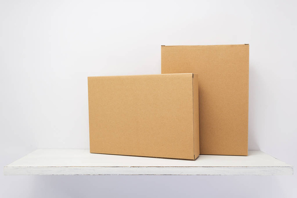 cardboard box on wooden shelf  - Φωτογραφία, εικόνα