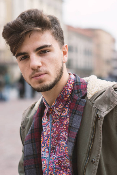Confident young man close up portrait in the city center of Bologna, Italy. - Fotó, kép