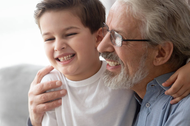 Primer plano del abrazo de abuelo feliz divirtiéndose con el nieto
 - Foto, imagen