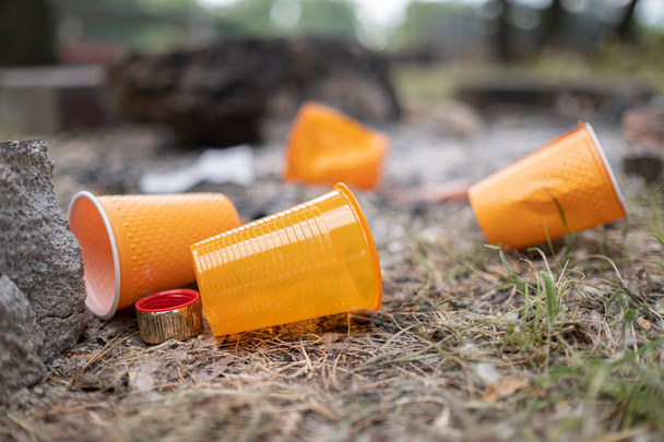 Cristal plástico desechable naranja o tazas utilizadas para beber agua en un recipiente - Concepto de problema ambiental. Residuos no compostables
 - Foto, Imagen