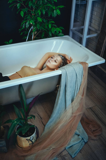 Όμορφο μοντέλο ποζάρει σε ένα μπάνιο με δημιουργικό ασημί μακιγιάζ - Φωτογραφία, εικόνα