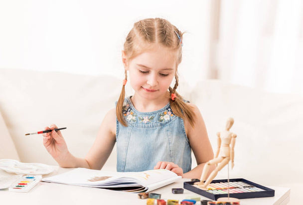 Little girl isdraws with watercolors - Fotó, kép