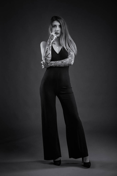Sensual full body woman portrait with long black dress and tatto - Foto, afbeelding