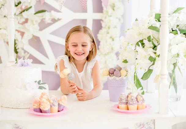 Little girl holding colorful sweet lollipops in the candy bar - Foto, imagen
