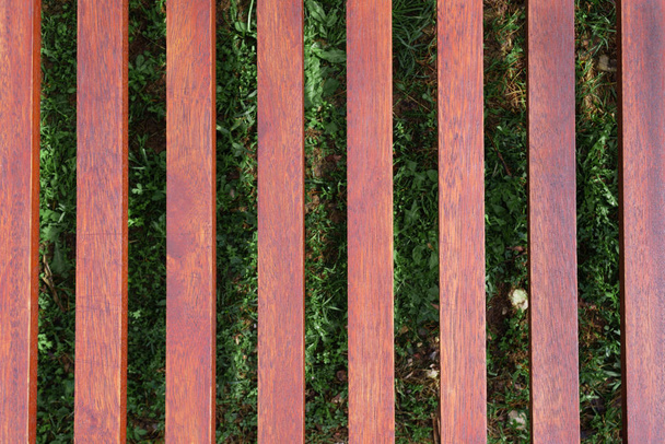 dřevěný lehátko na pozadí zelené trávy - Fotografie, Obrázek