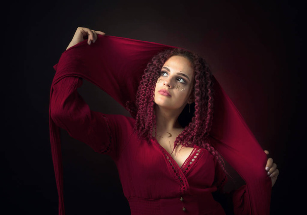 Retrato de una joven atractiva en un lujoso dres con capucha roja
 - Foto, Imagen