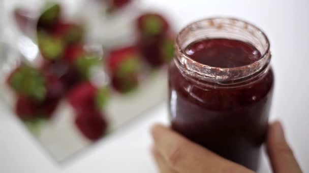 delicious fresh strawberry jam - marmalade and strawberry fruits background - Footage, Video
