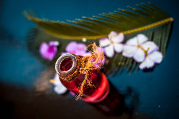 Biberiye konsantrasyonu veya özü, çiçekleri ve bazı yaprakları ile birlikte ahşap yüzeyüzerinde bir cam şişe. - Fotoğraf, Görsel