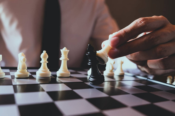 Closeup photo of businessman playing chess and beating black kin - Foto, immagini