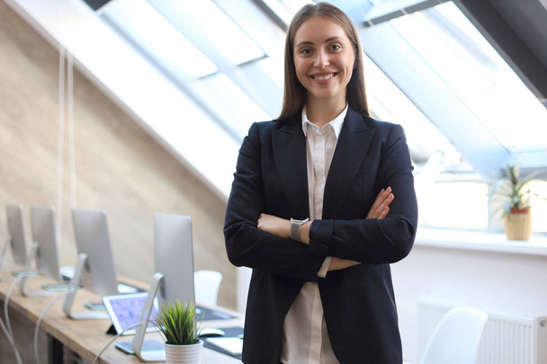 Attractive businesswoman standing near desk in the office. - Photo, image