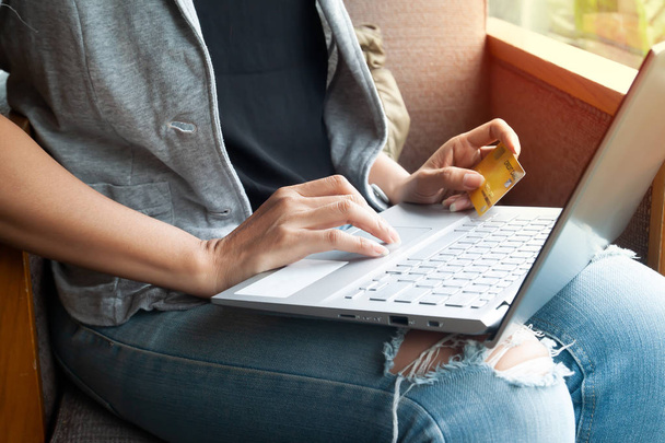 Молода жінка тримає кредитну картку і використовує ноутбук. Концепція інтернет-магазинів
 - Фото, зображення