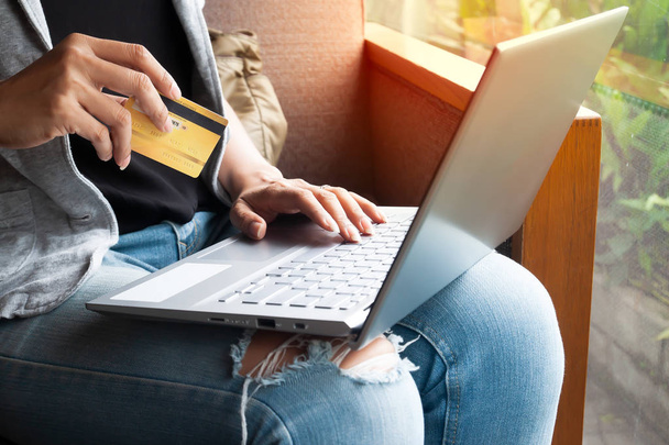 女性はノートパソコンやクレジットカードのショッピングをオンラインで手。クレジットカードを利用した決済取引 - 写真・画像