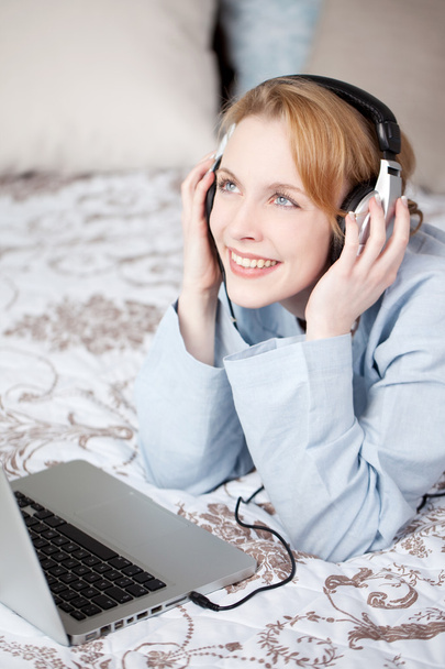 Happy young woman listening to music in bedroom - Foto, Bild