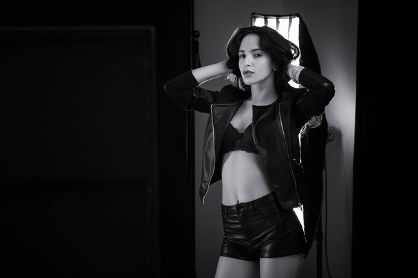 Sensual beautiful woman studio portrait with long hair wearing black jacket. Black and white image. - Zdjęcie, obraz